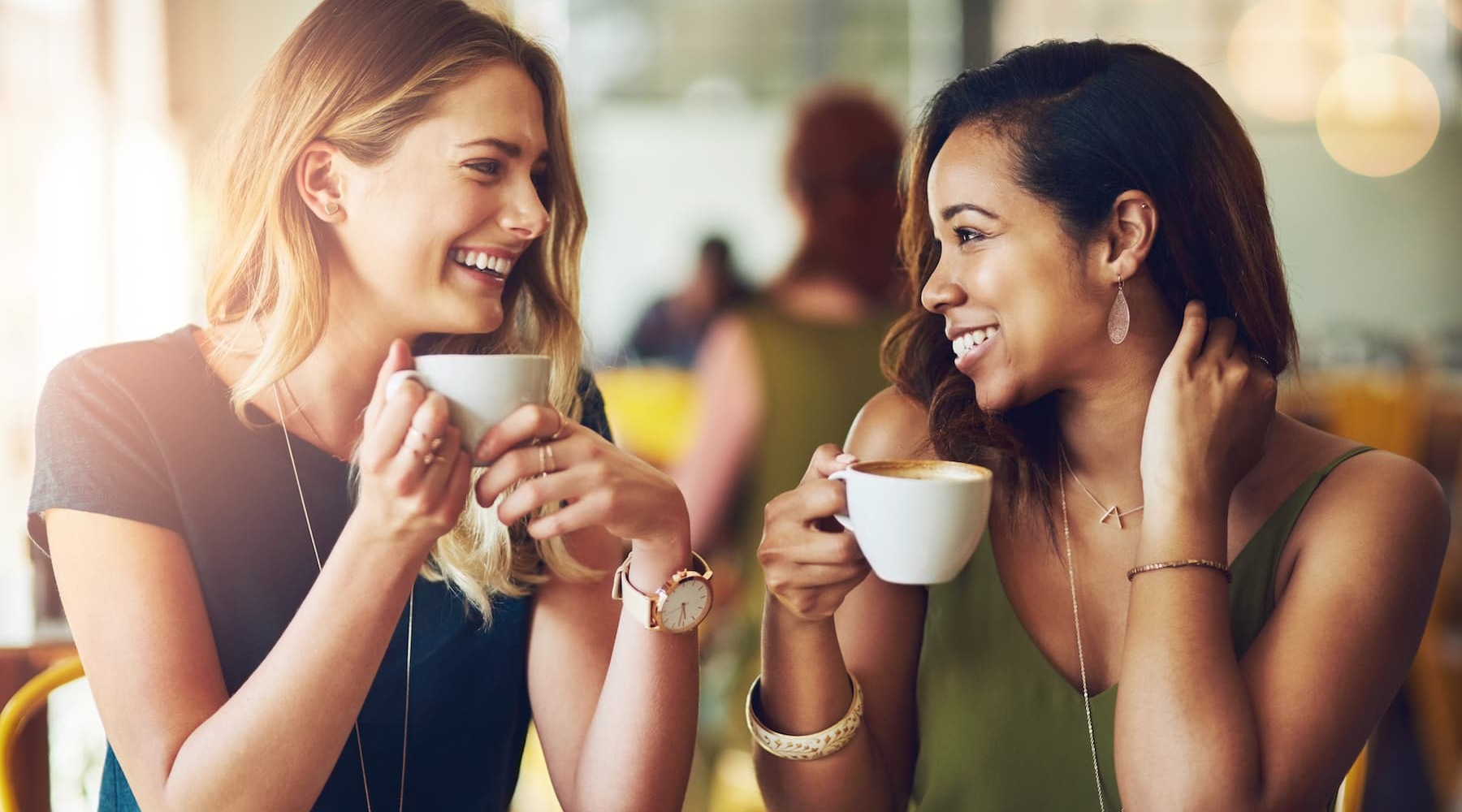 Neighborhood Conveniences Lifestyle image of two women sitting in a bar with mugs in hand